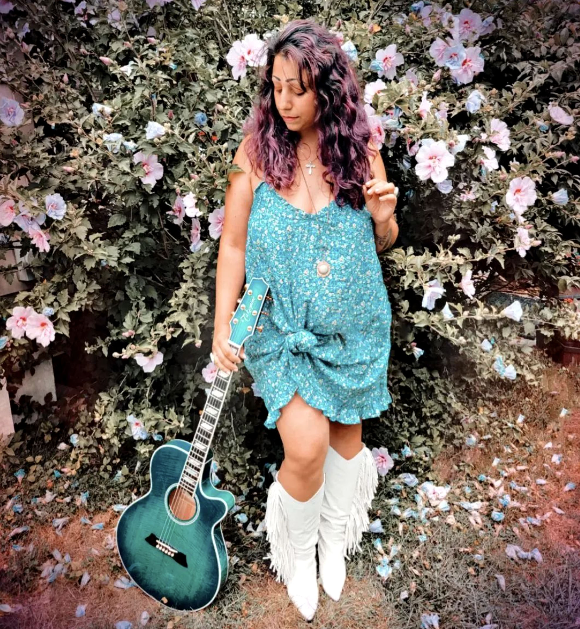 Nikki Briar with teal guitar.